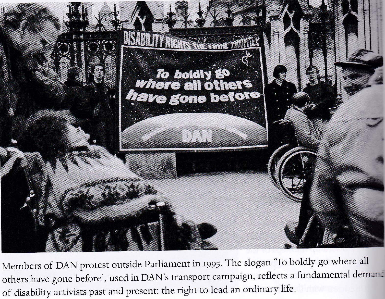 Black and white photograph showing members of the Direct Action Network (DAN) protesting outside Parliament in 1995. A large banner depicts a starry night sky above a planet with the words 'DISABILITY RIGHTS THE FINAL FRONTIER', 'To boldly go where all others have gone before', and 'DAN'. Several activists, including some in wheelchairs, are gathered around the banner, appearing engaged and determined.